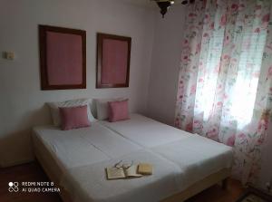 a bedroom with a bed with two books on it at Vasilis house in Kallirákhi