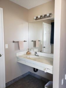 a bathroom with a sink and a mirror at Lamplighter Inn in Three Hills