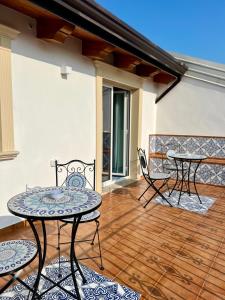 a patio with two tables and chairs on a deck at TEA Luxury - Praia a Mare in Praia a Mare