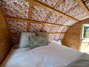 1 dormitorio con 1 cama en una habitación de madera en Alnmouth Glamping, en Alnmouth