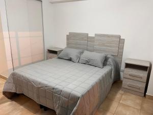 a bedroom with a bed with a wooden headboard at Hermoso Depto para 4 o 6 personas in Salta