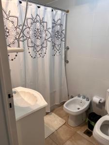 a bathroom with a shower curtain and a toilet and a sink at Hermoso Depto para 4 o 6 personas in Salta