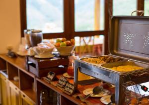 cocina con mesa con comida y TV en Gocta Andes Lodge, en Cocachimba