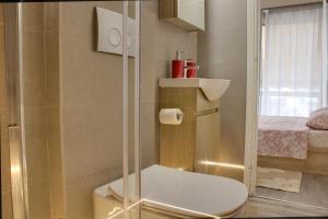 a bathroom with a shower with a toilet and a bed at Modern Cozy Apartment in Downtown Athens in Athens +10 photos