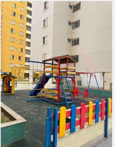 a playground with a slide and a swing at Apartamento moderno com 03 quartos e 02 garagens in Campinas