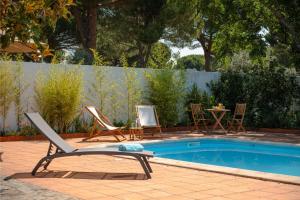 una piscina con 2 sillas de jardín, una mesa, una mesa y sillas en AmendoeirasHouse, en Abrantes