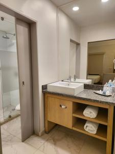 een badkamer met een wastafel en een spiegel bij Bluu Hotel Aeropuerto Monclova-Frontera in Monclova