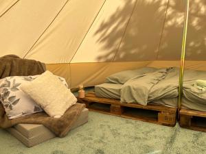 a bedroom with a tent with a bed and a chair at Zarevo Glamping in Skobelevo