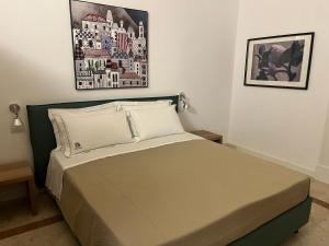 ein Bett in einem Schlafzimmer mit einem Bild an der Wand in der Unterkunft VIANNA SUITES SPA in Lecce