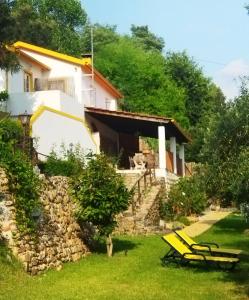 een huis met een stenen muur en stoelen in de tuin bij Magnolias Cottage in Lousã
