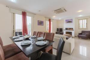 a dining room and living room with a table and chairs at Villa Felice in Maa