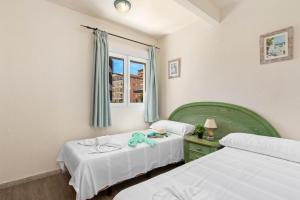 een slaapkamer met 2 bedden en een raam bij Apartamento Arenal 4 - PlusHolidays in Calpe