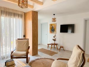 a living room with a couch and chairs and a tv at Mawa Cottage in Ulcinj