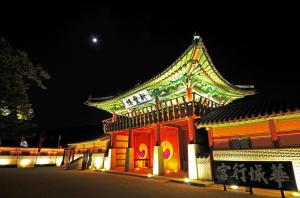 un bâtiment avec un toit éclairé la nuit dans l'établissement Hwaseong Guesthouse, à Suwon