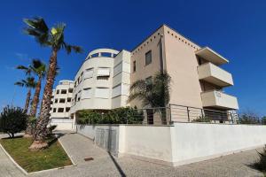 a building with palm trees in front of it at "ELLE home" ATTICO panoramico in Lecce