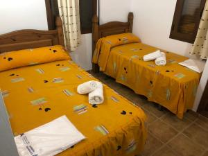 Cuevas del CampoにあるHoya de la virgenの黄色いシーツとタオルが備わる客室内のベッド2台