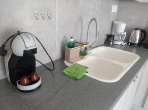 a kitchen counter with a sink and a coffee maker at Pireas view in Piraeus