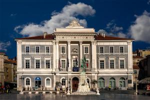 a large white building with a statue in front of it at Apartments Angela in Piran