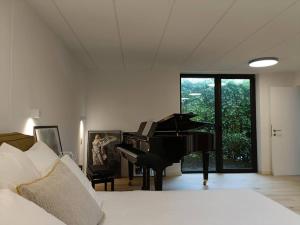 a bedroom with a bed and a piano in it at 100% Vacation feeling by the Waterside: Pian'Eau in Ghent