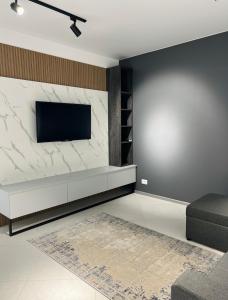 a living room with a tv on a marble wall at VIP Апартаменти подобово in Lutsk