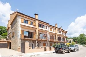 a large building with cars parked in front of it at Ca la Gloria in Vallcebre