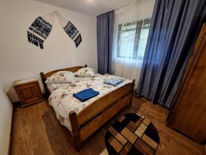 um quarto com uma cama e uma janela com cortinas em Cabana Georgiana Maria em Gheţari