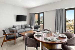 Casa Barros Vacation Condos في مازاتلان: غرفة معيشة مع طاولة وكراسي وأريكة