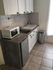 a kitchen with a microwave on top of a counter at ANTONY Centre à 150m du RER Antony, des commerces et du marché. in Antony