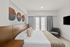 Habitación de hotel con cama y TV en Casa Barros Vacation Condos en Mazatlán