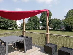 a patio with a table and a canopy on a deck at La Tiny de Jeff in Uzel +9 photos