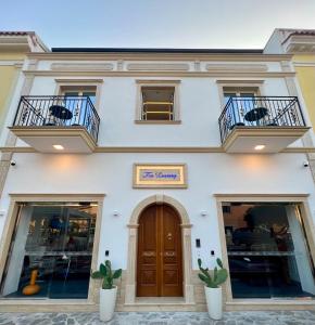 un edificio blanco con 2 balcones y una puerta en TEA Luxury - Praia a Mare, en Praia a Mare