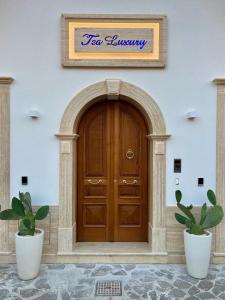 uma porta de madeira num edifício com dois vasos de plantas em TEA Luxury - Praia a Mare em Praia a Mare