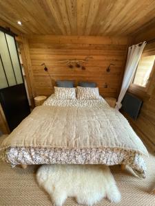 a bedroom with a bed with a wooden ceiling at Le Pika in Hauteluce