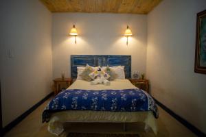 um quarto com uma cama com um urso de peluche em Vila ACONCHEGO AZUL 2 em Aracê