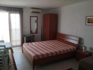 a bedroom with a bed with a red and white stripes at Apartment Boksi in Ulcinj