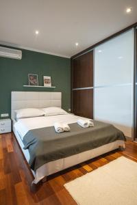 ein Schlafzimmer mit einem großen Bett mit zwei Handtüchern darauf in der Unterkunft Lumaja luxury apartman in Biograd na Moru