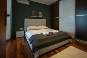 a bedroom with a bed with two towels on it at Lumaja luxury apartman in Biograd na Moru