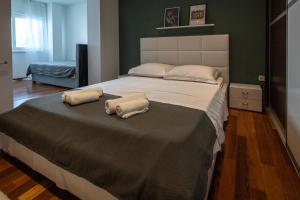 ein Schlafzimmer mit einem großen Bett mit zwei Kissen darauf in der Unterkunft Lumaja luxury apartman in Biograd na Moru