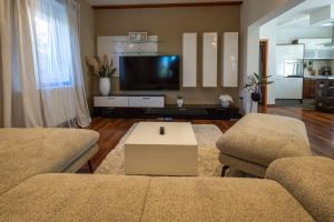 ein Wohnzimmer mit 2 Sofas und einem TV in der Unterkunft Lumaja luxury apartman in Biograd na Moru