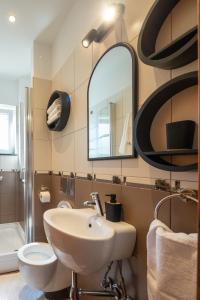 ein Badezimmer mit einem Waschbecken, einem WC und einem Spiegel in der Unterkunft Lumaja luxury apartman in Biograd na Moru