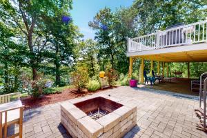 a patio with a fire pit and a deck at The Lakeside Landing in Plymouth