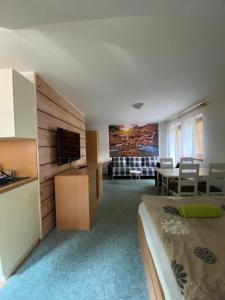 a hotel room with a bed and a dining room at Pension Sima in Harrachov