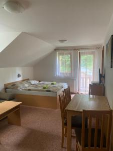 a bedroom with a bed and a table in it at Pension Sima in Harrachov
