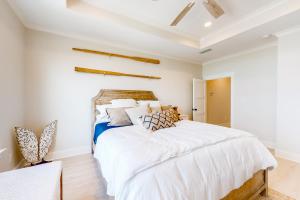 ein Schlafzimmer mit einem großen Bett mit weißer Bettwäsche in der Unterkunft Cadillac Margarita in Dauphin Island