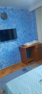 a bedroom with a blue wall with a desk at ARANGO House in Făgăraş