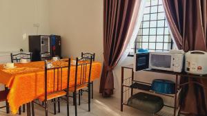 uma sala de jantar com uma mesa e um micro-ondas em Anjung KLIA House 72 With Neflix & Airport Shuttle em Banting