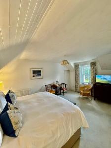 Un dormitorio con una gran cama blanca y una mesa en Achnacriche B&B en Bonnavoulin
