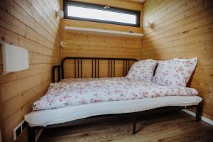 Bett in einem Holzzimmer mit Fenster in der Unterkunft Kontenery Kapalica 