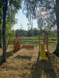 a group of wooden playground equipment in a park at Arkādija Krosti in Gaiduļi