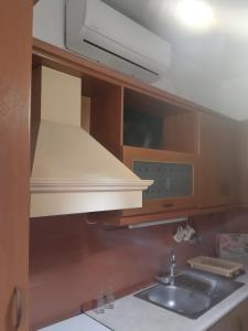 a kitchen with a sink and a hood over a stove at House SOFIA in Stavros